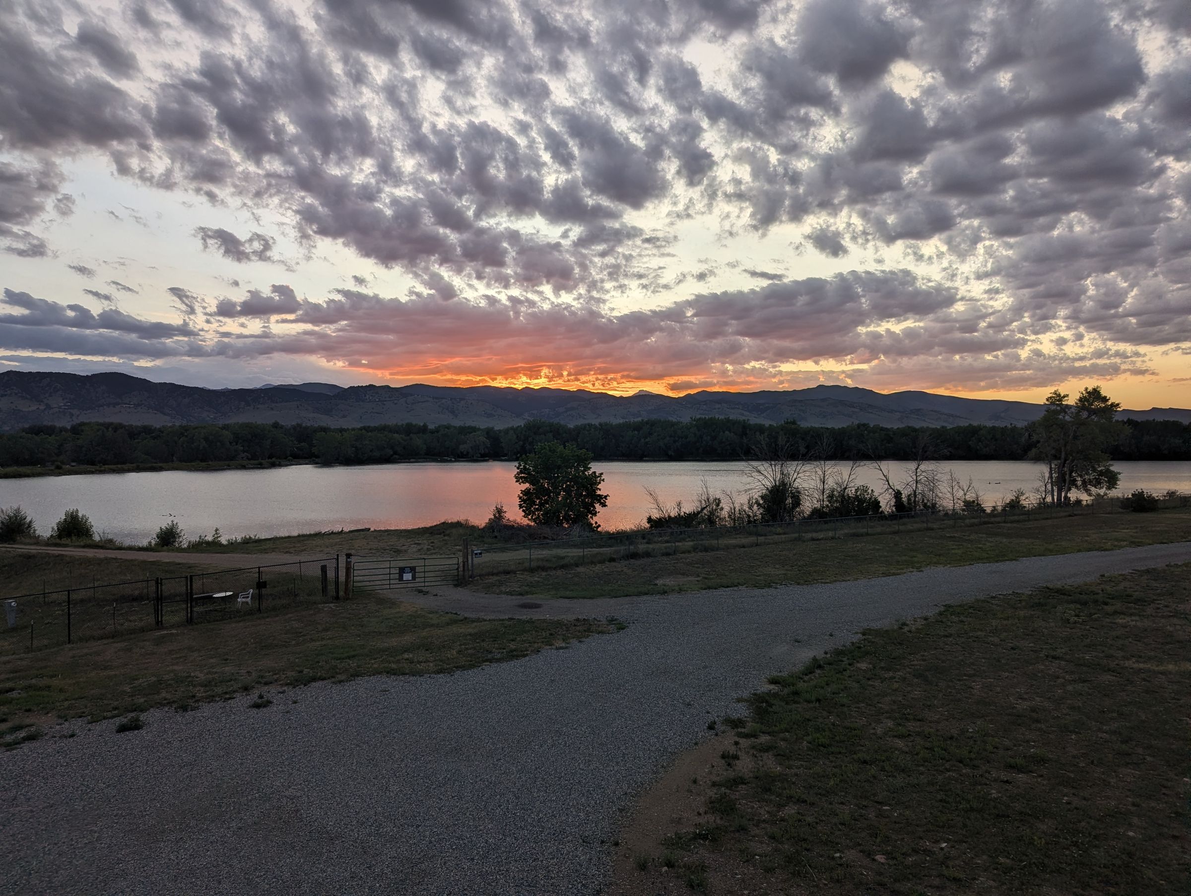 Orange sunset breaking under a mackerel sky above the foothills.